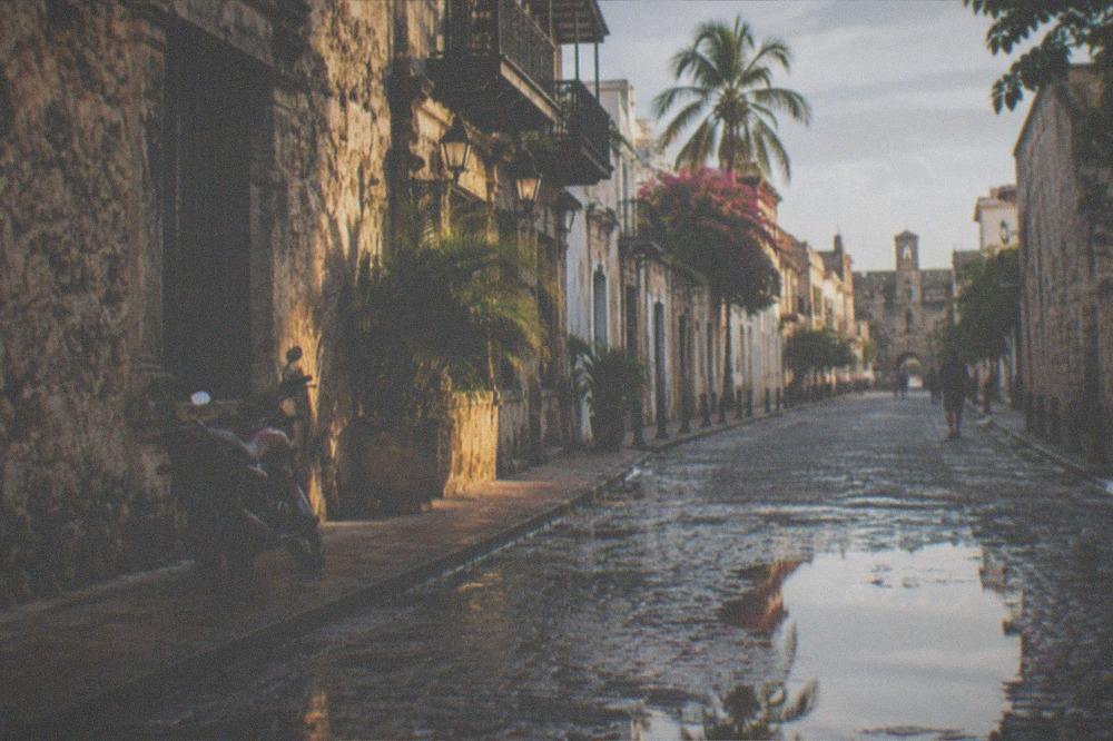 Historic stone buildings and a cobblestone street in a colonial city