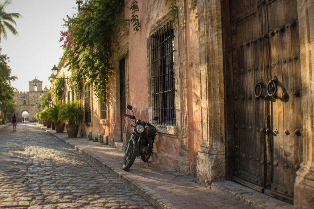 Cobblestone colonial street with pastel stone buildings and wooden doors