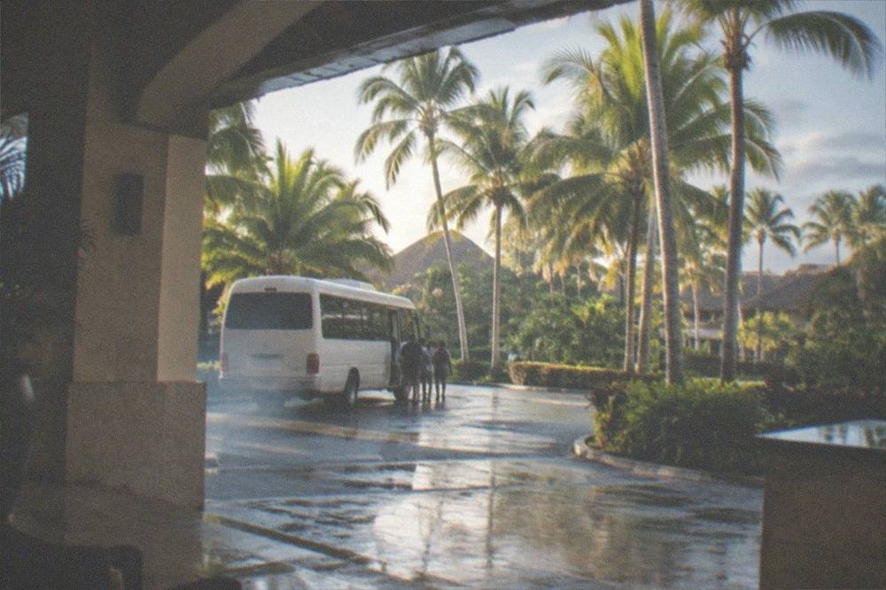 Minibus waiting at a resort entrance driveway in the early morning
