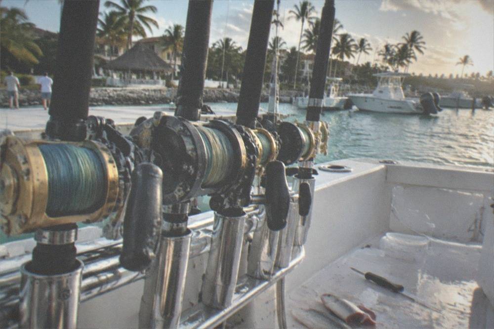 Close view of fishing rods in a rack on the stern of a charter boat