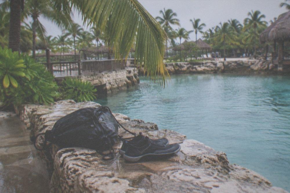 Wet bag and water shoes resting on a bench beside a lagoon