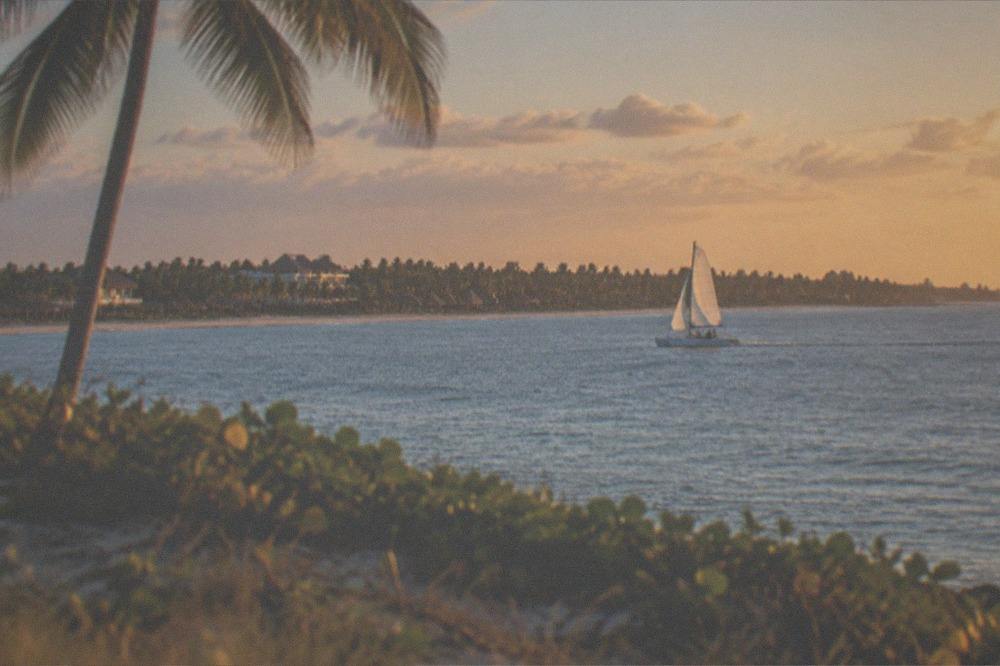 A small catamaran under way along the Punta Cana coast in late afternoon light