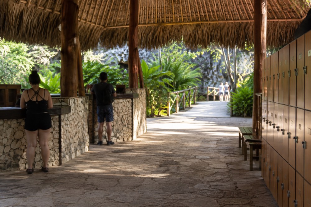 Thatched entrance plaza with wristband counters at a Cap Cana eco-adventure park